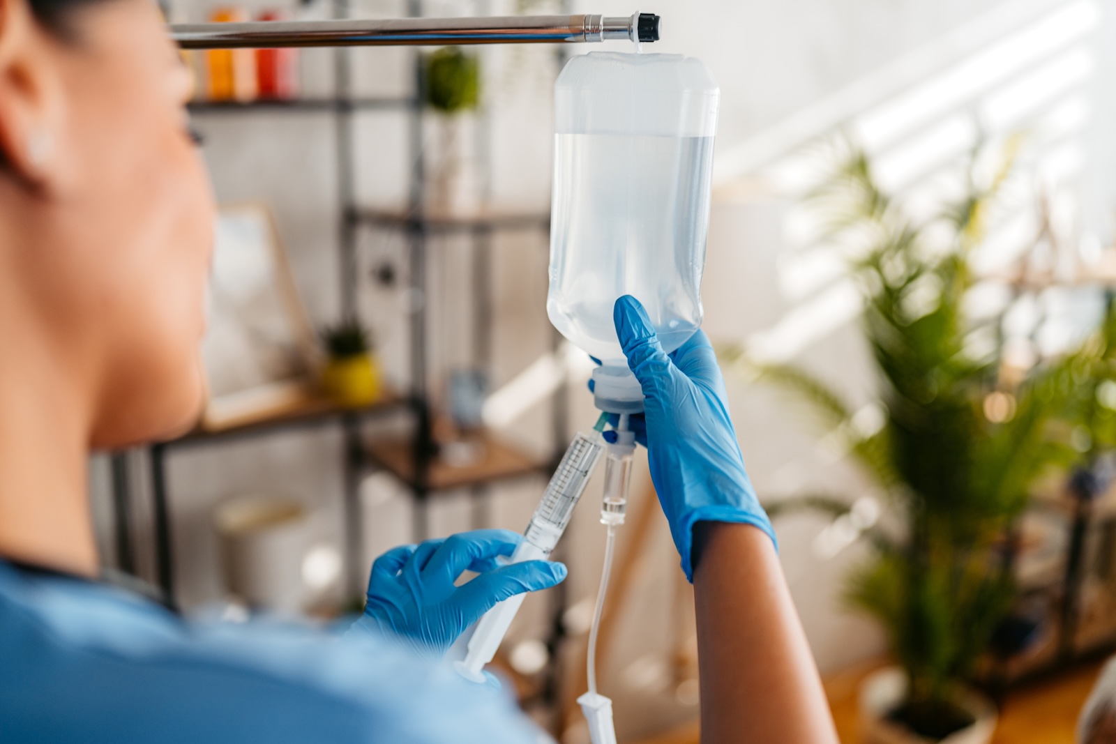 Home care nurse adjusting and preparing an IV drip inside an apartment, iron infusion 2